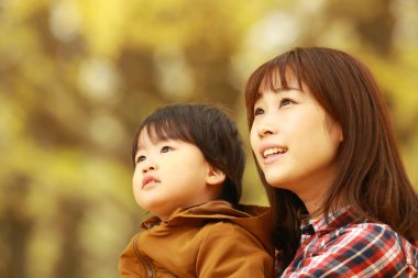 Genç Asyalı anne ve küçük oğlu parkta eğleniyorlar.  