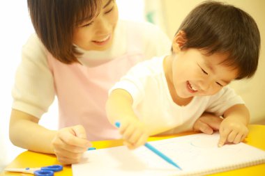 Annesiyle resim yapan küçük sevimli bir çocuk. 