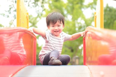 Parktaki küçük Asyalı çocuk oyun parkında 