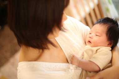 Yeni doğmuş bir bebek ve gülümseyen bir anne.