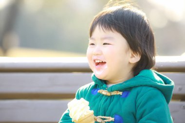 Parkta dondurma yiyen küçük kız.