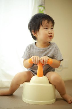 Asyalı bebek evde oyuncakla oynuyor. 