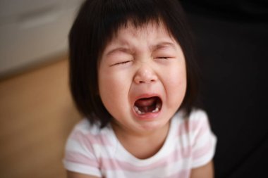 Küçük Japon kız odada ağlıyor. 