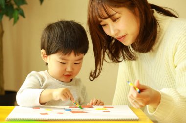 Genç anne ve tatlı küçük oğlu evde birlikte zaman geçirip, eğitim oyunları oynuyorlar.