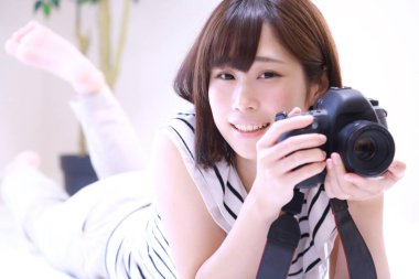 Genç bir kadın evinin fotoğrafını çekiyor.