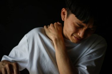 Kapalı alanda sırtı ağrıyan üzgün Asyalı adam