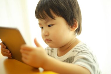 Tablet terminal kullanan bir çocuğun resmi