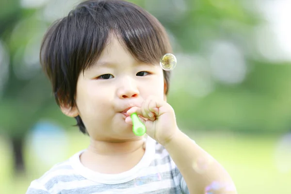 Asiatico Piccolo Ragazzo Soffiando Sapone Bolle Parco All Aperto — Foto Stock