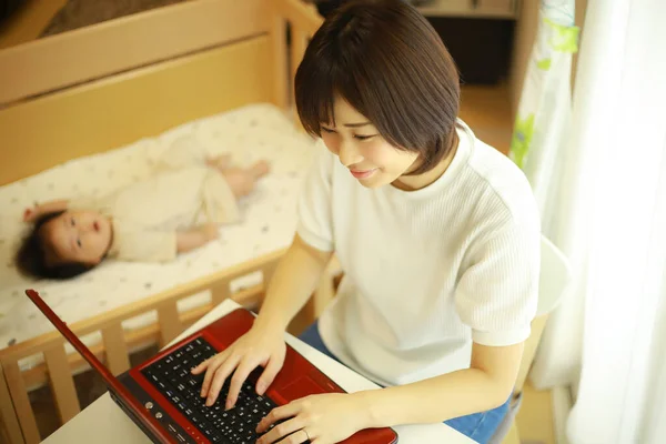Młoda Japońska Kobieta Pomocą Czerwonego Laptopa Podczas Pracy Domu — Zdjęcie stockowe