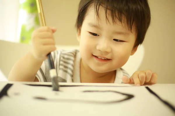 Kleiner Japanischer Junge Übt Mit Pinsel Kalligraphie — Stockfoto
