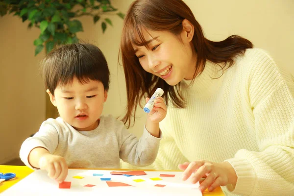 幼い母親とかわいい息子が家で一緒に教育ゲームをしたり — ストック写真