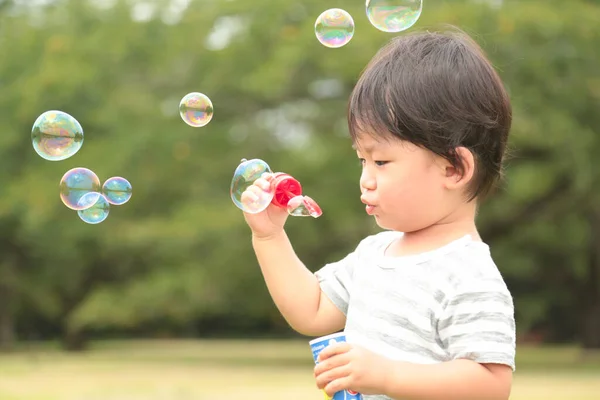 Азиатский Маленький Мальчик Раздувает Мыльные Пузыри Парке Открытом Воздухе — стоковое фото