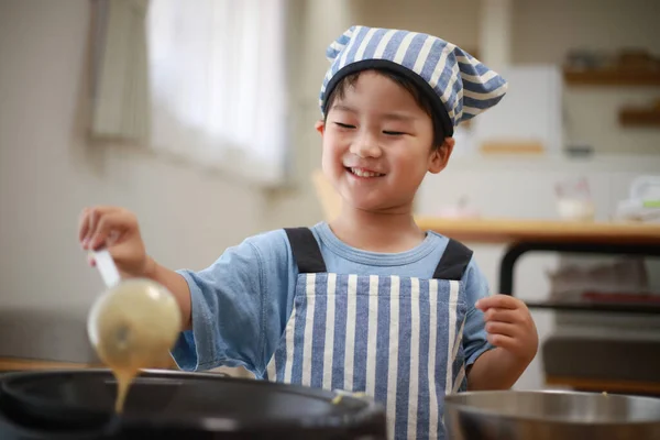 Liten Japansk Pojke Matlagning Pannkakor Köket Med Kock Hatt Huvudet — Stockfoto