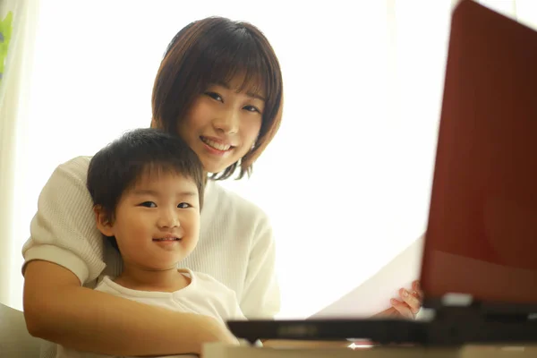 亚洲的年轻妇女和她的小儿子使用笔记本电脑 — 图库照片