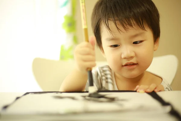 Poco Japonés Chico Práctica Con Cepillo Caligrafía — Foto de Stock