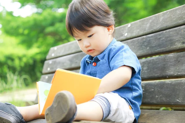 Asyalı Küçük Çocuk Parkta Kitap Okuyor — Stok fotoğraf
