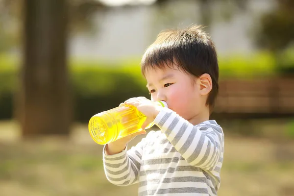 Bambino Che Beve Dalla Bottiglia Nel Parco — Foto Stock