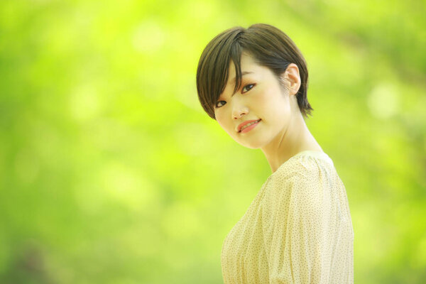 Portrait of young asian woman looking at camera in the park