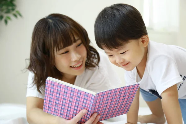 Hermosa Mujer Asiática Leyendo Libro Con Pequeño Hijo — Foto de Stock