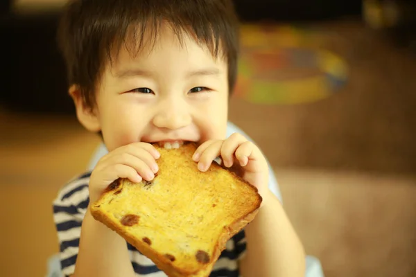 Mały Chłopiec Jedząc Chleb Domu — Zdjęcie stockowe