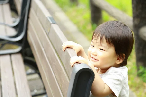 Parktaki Bankın Yanındaki Küçük Asyalı Çocuk — Stok fotoğraf