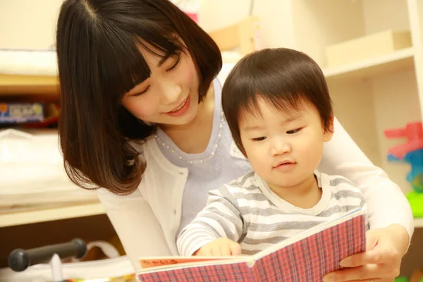 Азиатская Женщина Читает Книгу Маленьким Сыном — стоковое фото