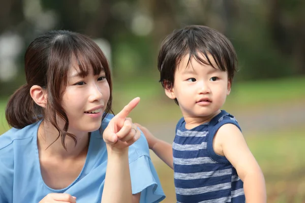 Giovane Madre Asiatica Mostrando Qualcosa Suo Bambino Nel Parco — Foto Stock