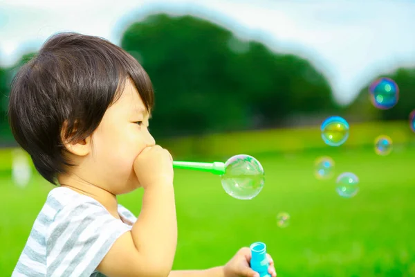 Asian Little Boy Blowing Soap Bubbles Park Outdoors Royalty Free Stock Images