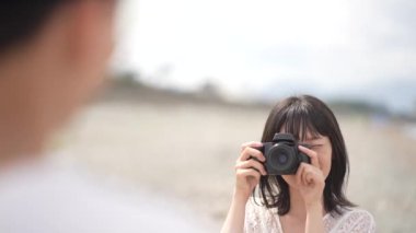 Gülümseyen Japon kadın dijital kamerayla fotoğraf çekiyor