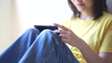 Genç Asyalı kadın akıllı telefon kullanıyor. 