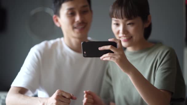 Alegre Jovem Casal Sentado Juntos Usando Smartphone Casa — Vídeo de Stock