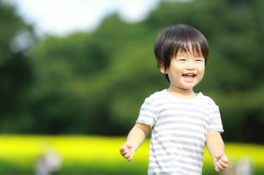 Parkta koşan Asyalı küçük çocuk. 