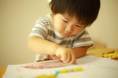 Güzel çocuk evde resim çiziyor.