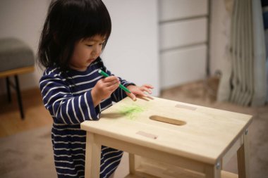 Evde çizim yapan küçük tatlı bir kız. 