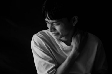 Kapalı alanda sırtı ağrıyan üzgün Asyalı adam