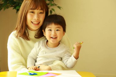 Genç anne ve tatlı küçük oğlu evde birlikte zaman geçirip, eğitim oyunları oynuyorlar.