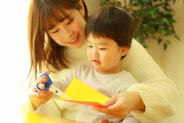 Genç anne ve tatlı küçük oğlu evde birlikte zaman geçirip, eğitim oyunları oynuyorlar.