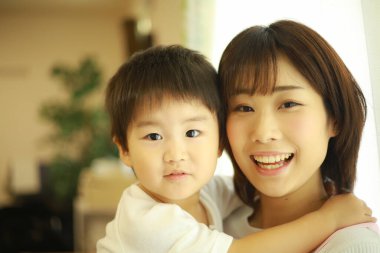 gülümseyen Asyalı genç kadın ve küçük oğlu  