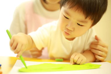 Annesiyle resim yapan küçük sevimli bir çocuk. 