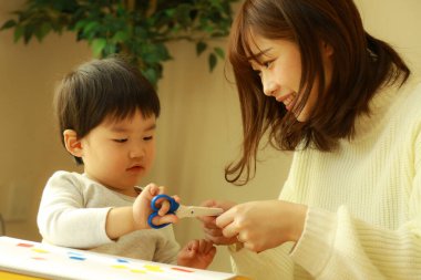 Genç anne ve tatlı küçük oğlu evde birlikte zaman geçirip, eğitim oyunları oynuyorlar.