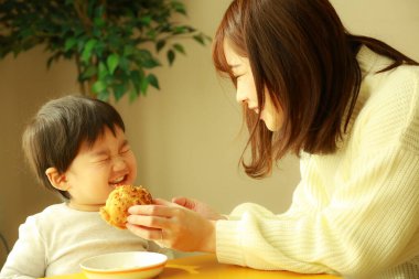 Anne ve oğul kahvaltılarını evde yapıyorlar.