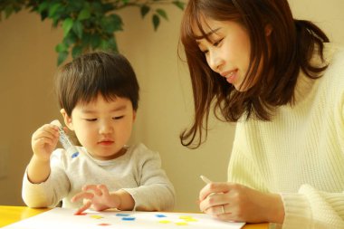 Genç anne ve tatlı küçük oğlu evde birlikte zaman geçirip, eğitim oyunları oynuyorlar.