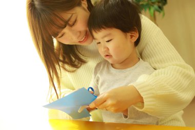 Genç anne ve tatlı küçük oğlu evde birlikte zaman geçirip, eğitim oyunları oynuyorlar.