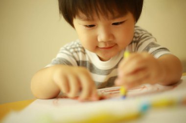 Güzel çocuk evde resim çiziyor.