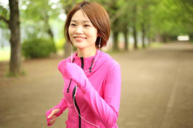 Bulanık arka planda spor yapan güzel Asyalı kadın.