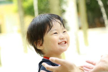 Parkta gülen sevimli Asyalı çocuk. 