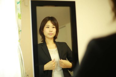 Siyah takım elbiseli Asyalı genç kadının portresi. 