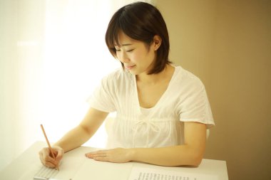 Evdeki masasında çalışan genç bir kadın..