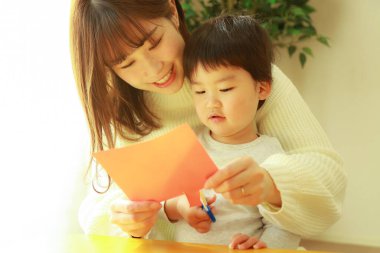 Genç anne ve tatlı küçük oğlu evde birlikte zaman geçirip, eğitim oyunları oynuyorlar.