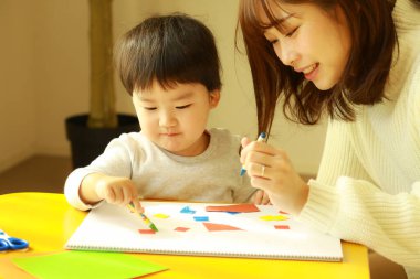 Genç anne ve tatlı küçük oğlu evde birlikte zaman geçirip, eğitim oyunları oynuyorlar.